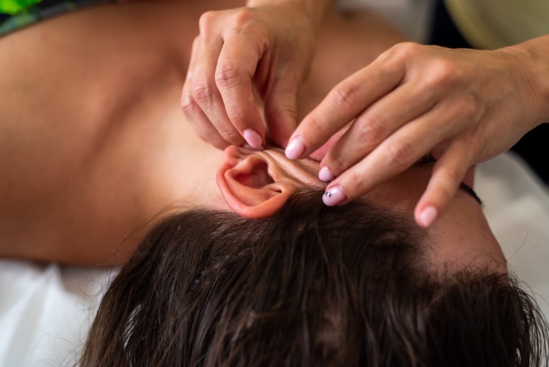 Frau erhält Faszien-Massage im Gesicht